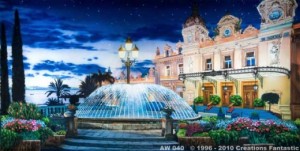 A brightly lit fountain stands in front of an ornate building with domes, surrounded by colorful flowers and trees, creating a scenic backdrop under a starry sky.