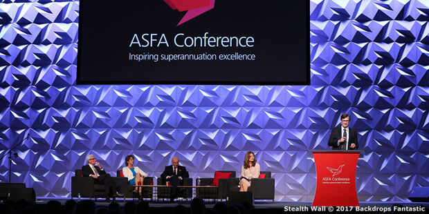 Panelists sit on a stage beneath a screen reading "ASFA Conference: Inspiring Superannuation Excellence," while a speaker stands at a podium, discussing the innovative modular systems transforming financial categories.