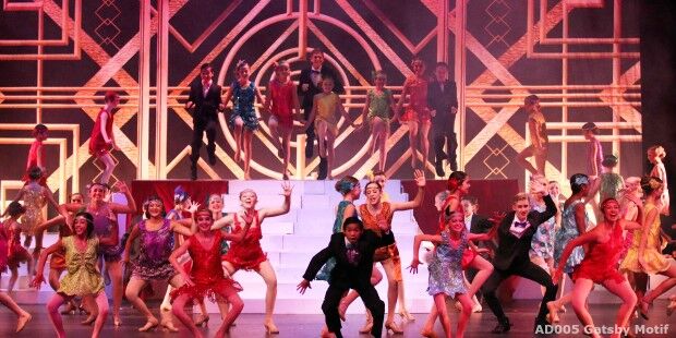 A lively group of performers in colorful costumes dance energetically on a stage, their movements fluid like they're gliding on sliders, with geometric designs and steps in the background.